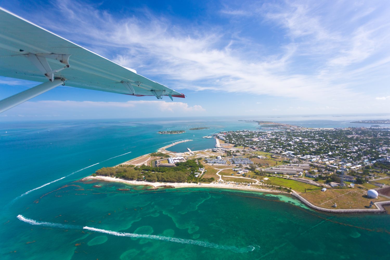 A view from an airplane of the Florida Keys, overlooking a body of land and the ocean.