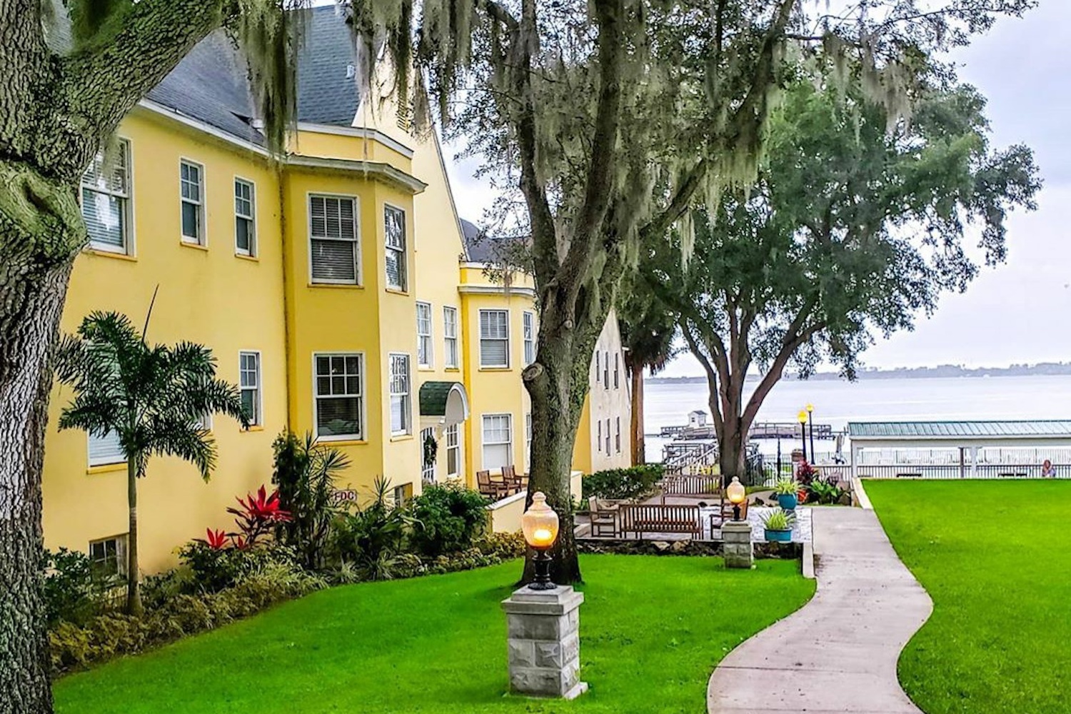 Yellow building in front of sidewalk near body of water