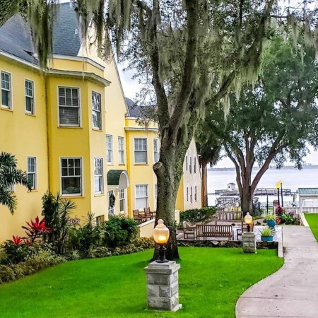 Yellow building in front of sidewalk near body of water