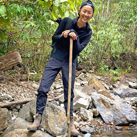 Chef Kristen Kish poses while crossing a stream in Panama's Chiriqui province.