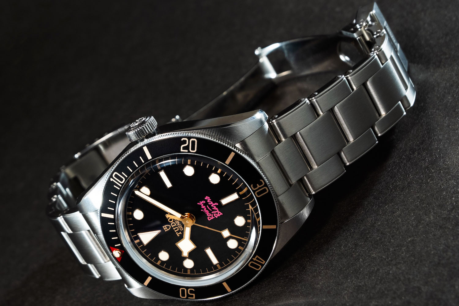a black-faced silver Rowing Blazer x Tudor watch on a grey background