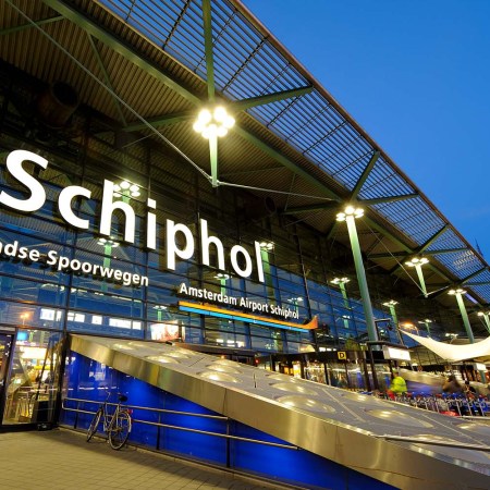 The entrance of Amsterdam Airport Schiphol in the evening.