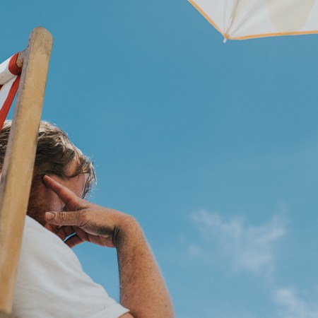 A man staring at the sky, sitting in a beach chair.
