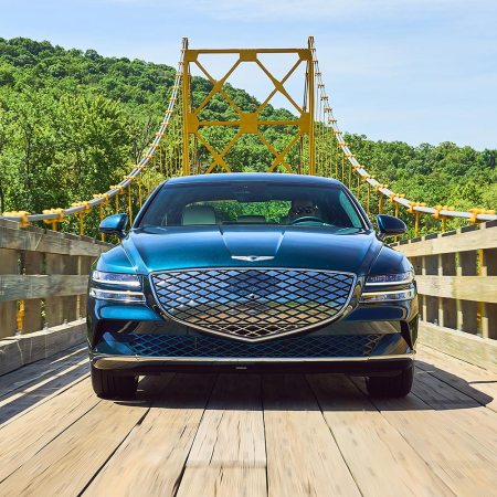 2023 Genesis Electrified G80 driving down a wooden bridge. We tested and reviewed the new EV sedan.
