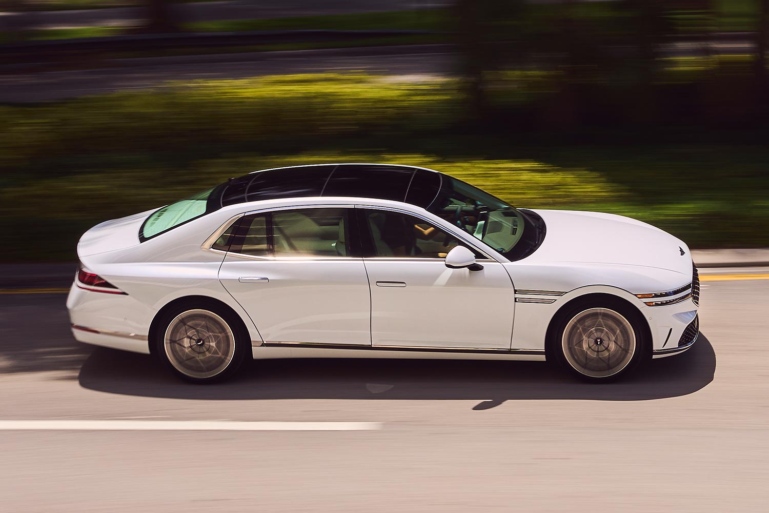 The profile of the 2023 Genesis G90 sedan as it drives down the road