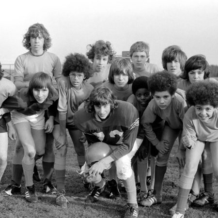 A football team of teenagers depicted in a black and white photo