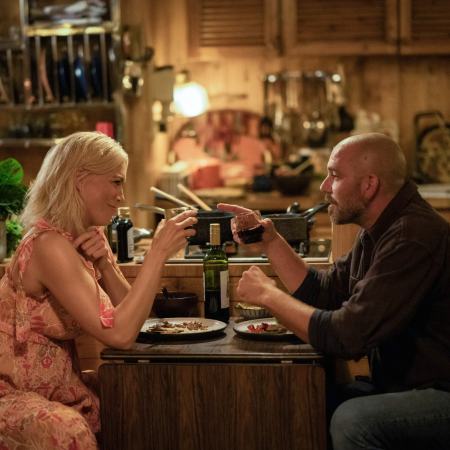 Rebecca Welton (Hannah Waddingham) and the guy on a houseboat in Amsterdam (Matteo van der Grijn) share a drink while he teaches her the Dutch word "gezellig"