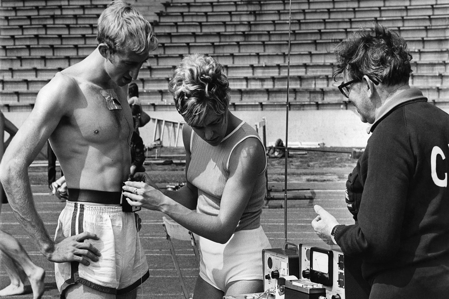 A woman preparing to measure an athlete's heart rate.