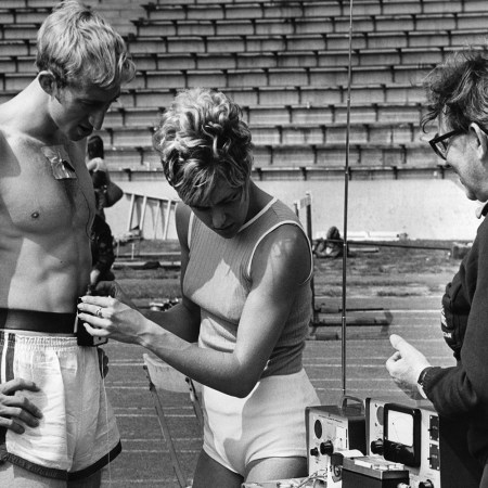 A woman preparing to measure an athlete's heart rate.