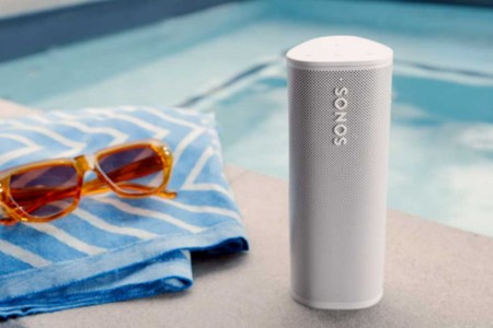 A Sonos Roam near a pool, towel and sunglasses. Sonos gear that is refurbished often nets you an extra discount.