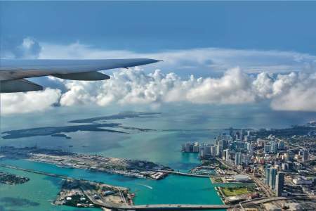Airplane flying over an ocean and bodies of land.