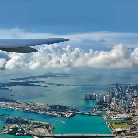 Airplane flying over an ocean and bodies of land.