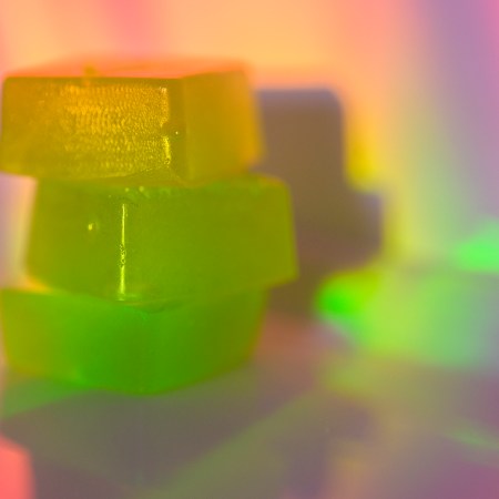A stack of edible cannabis gummies in rainbow light