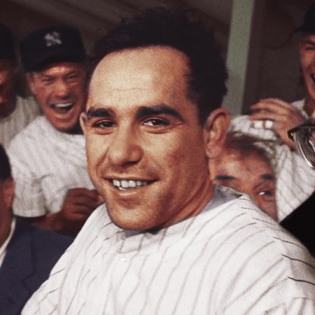 Yogi Berra in his Yankees uniform surrounded by laughing teammates and dapper men in suits during Mr. Berra's playing days
