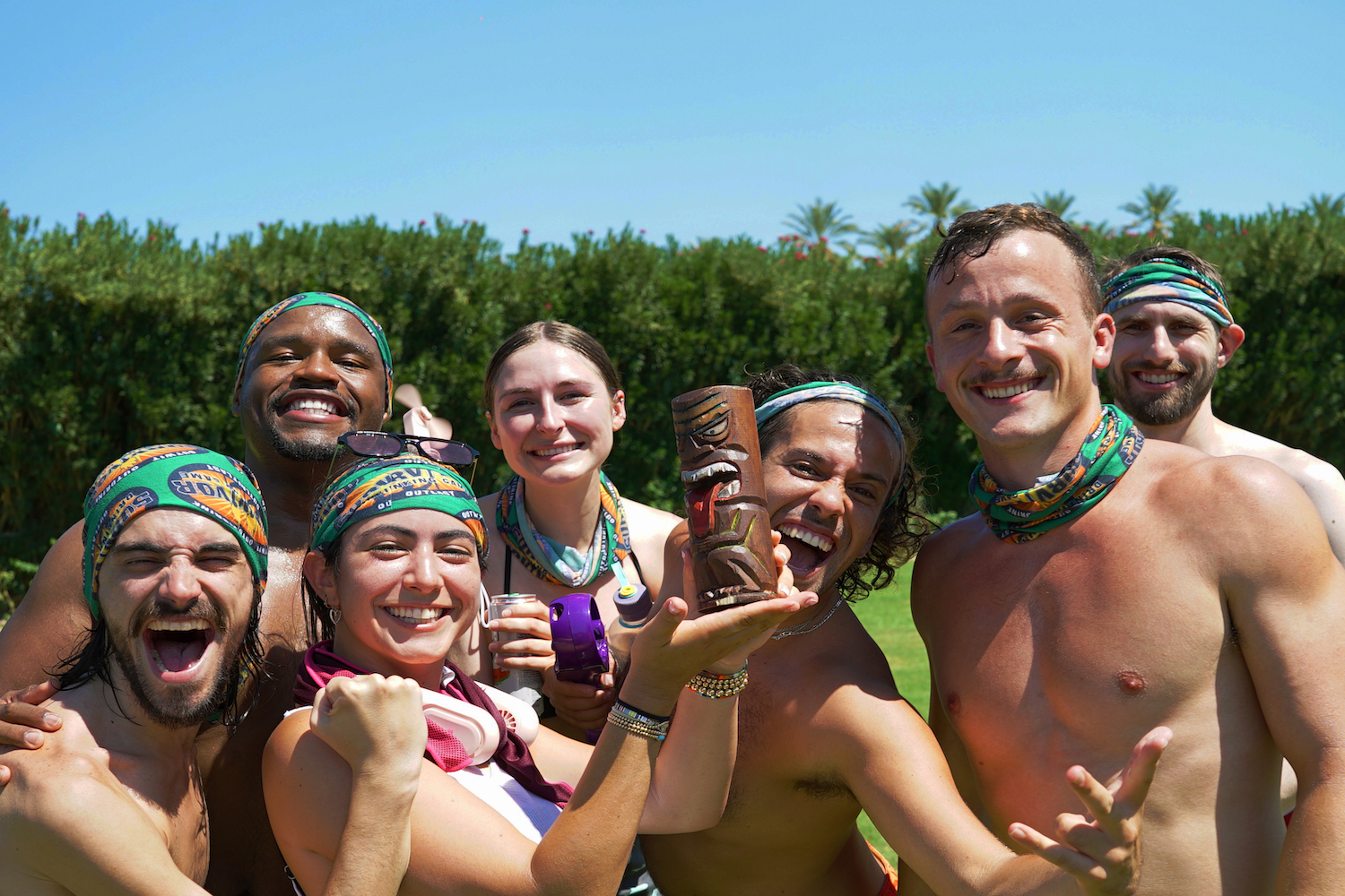 A group of people around a trophy.