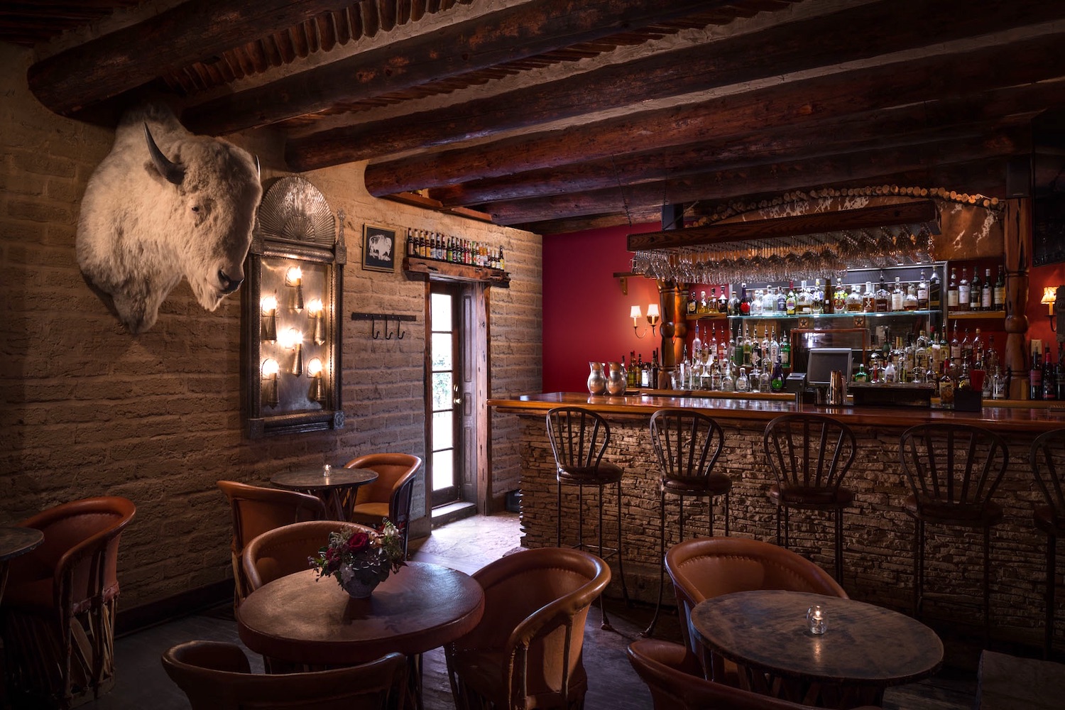 bar area with red walls, brown leather seating and buffalo headmount road trip stops austin marfa