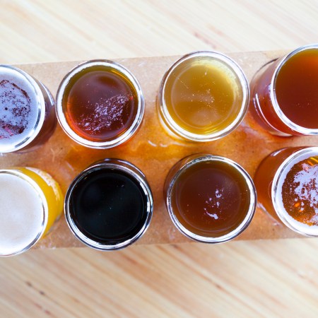 flight of 8 beers on a wooden board