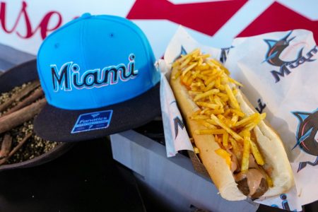loaded hot dog next to miami marlins hat