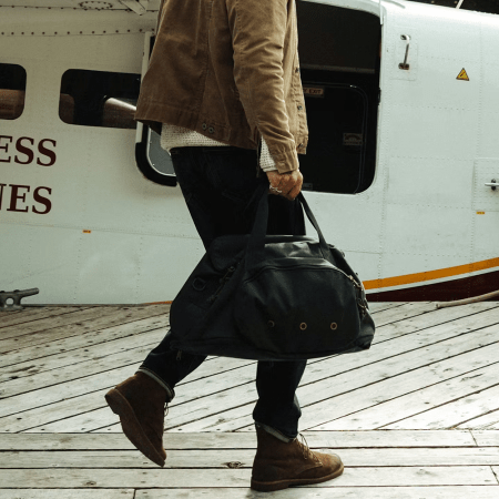 lifestyle image of man holding duffle bag