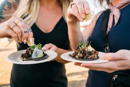people squeezing lime on food