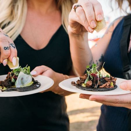 people squeezing lime on food