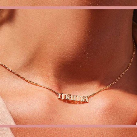 A woman wearing a necklace that spells "mama," a great piece o jewelry to gift this Mother's Day