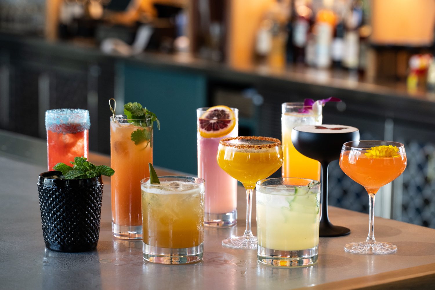 A spread of cocktails on a bar table.