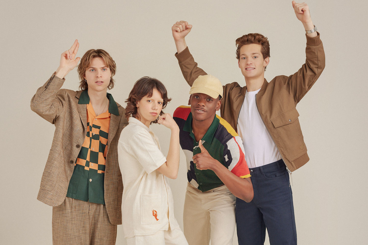 a photo of four models in Pericval x Seinfeld against a tan background