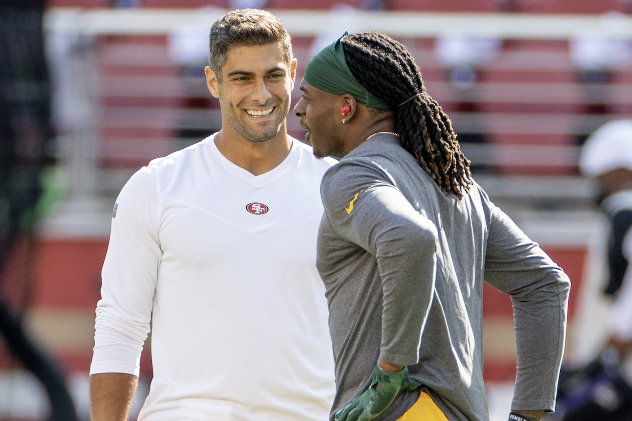 Jimmy Garoppolo speaks with Davante Adams before a 2021 game.