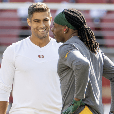 Jimmy Garoppolo speaks with Davante Adams before a 2021 game.