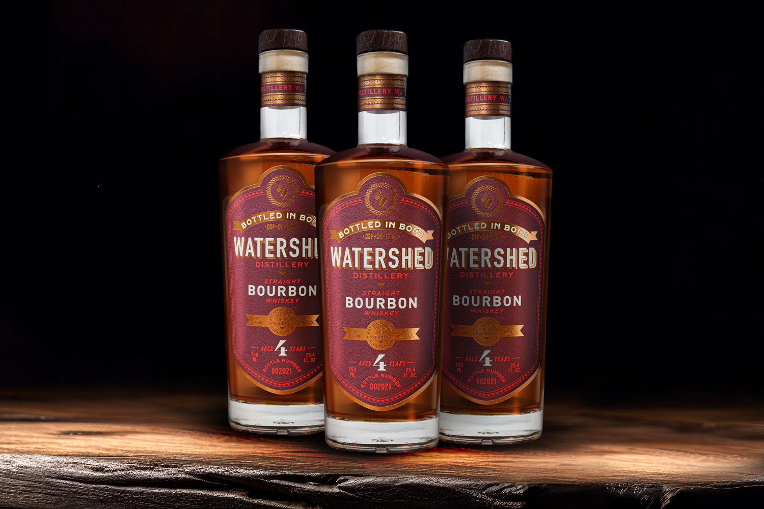 3 bottles of watershed whiskey on a wooden table