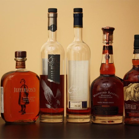 Five bottles of elevated bourbon on a table.
