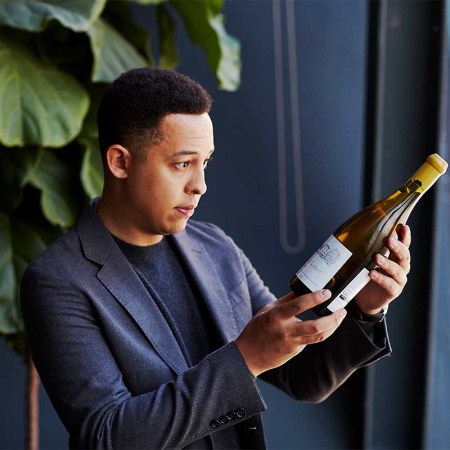 Thatcher Baker-Briggs, a 31-year old wine consultant with A-level celebrity clients, looking at a bottle of wine