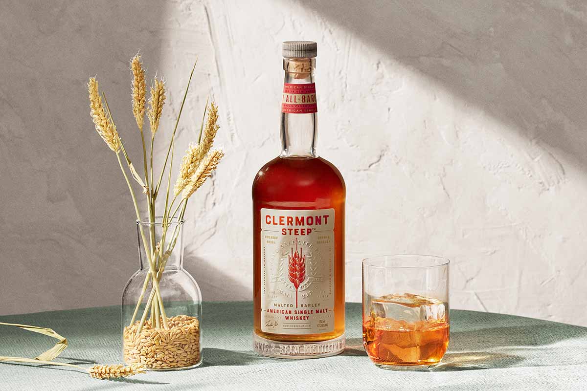 A bottle of Clermont Steep and a glass of ice and whiskey. Clermont is a new American Single Malt from the producers of Jim Beam.