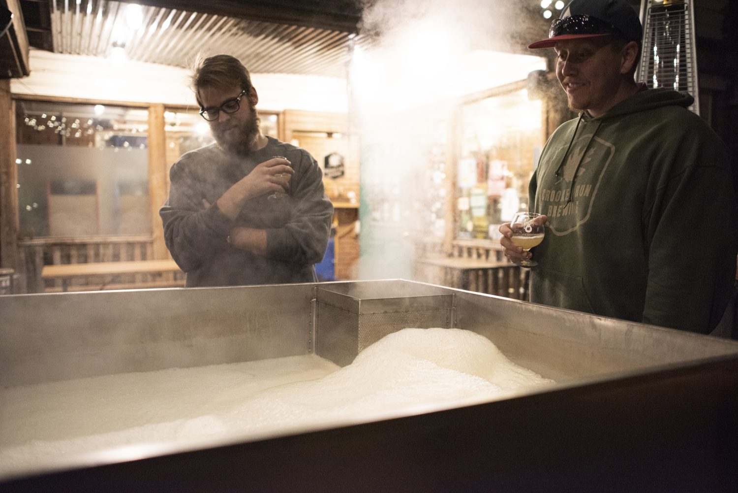 People looking over white substance in a machine