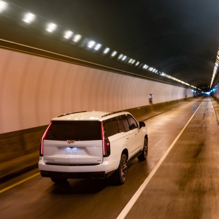The Cadillac Escalade driving through a tunnel. GM announced the electric Cadillac Escalade IQ will be unveiled in 2023.