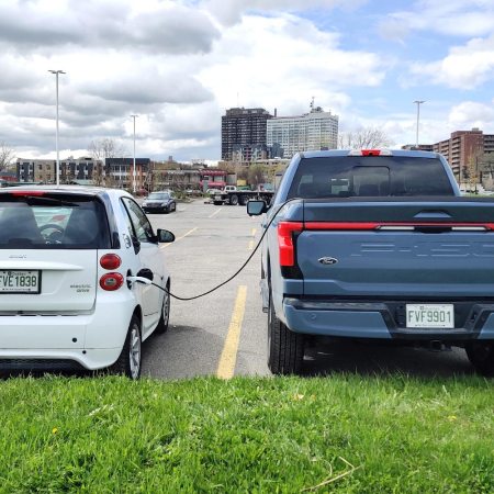 Vehicle-to-vehicle charging, as seen in a Ford F-150 Lightning charging a Smart Fortwo Electric Drive