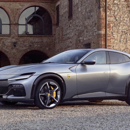 The Ferrari Purosangue SUV in silver sitting next to an old Italian villa