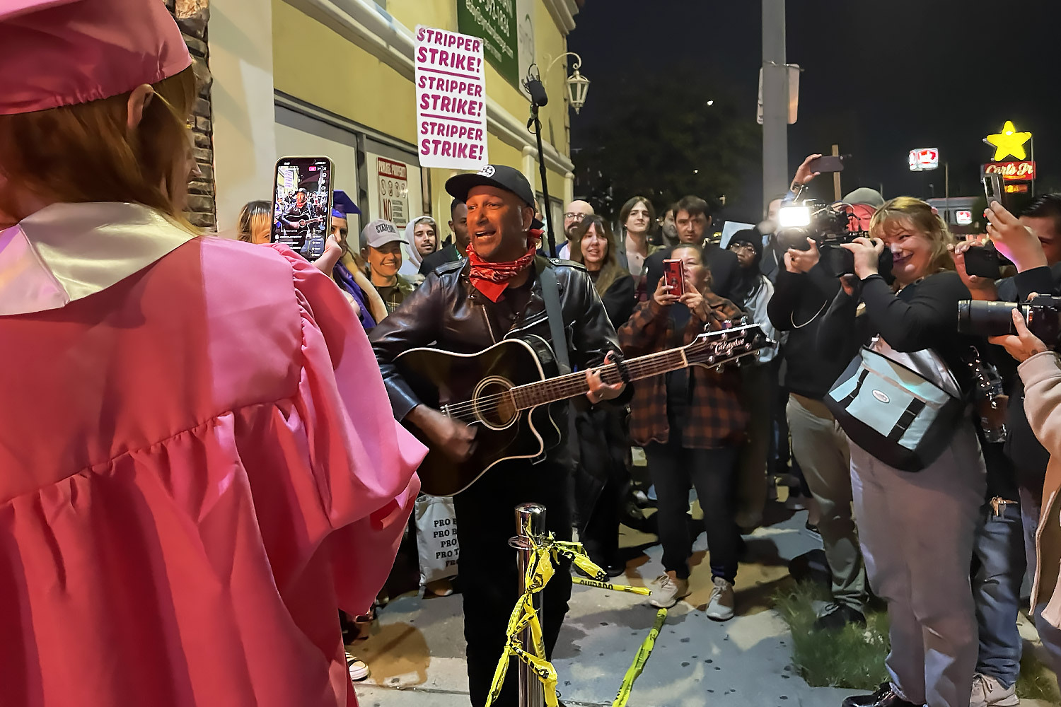 people striking with Tom Morello outside of strip club.