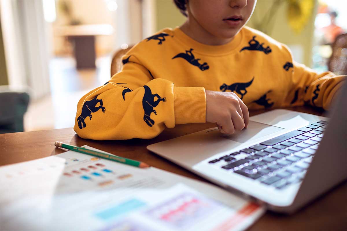 Close up of a young boy studying and doing homework using his laptop. Students are increasingly preferring ChatGPT to human tutors.
