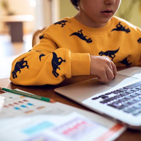 Close up of a young boy studying and doing homework using his laptop. Students are increasingly preferring ChatGPT to human tutors.
