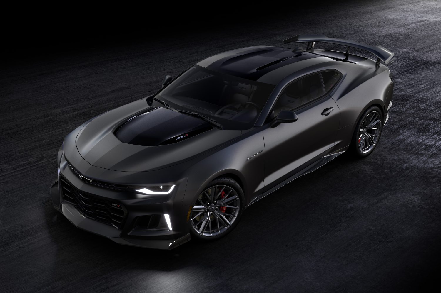 Black Chevrolet Camaro driving on black surface.