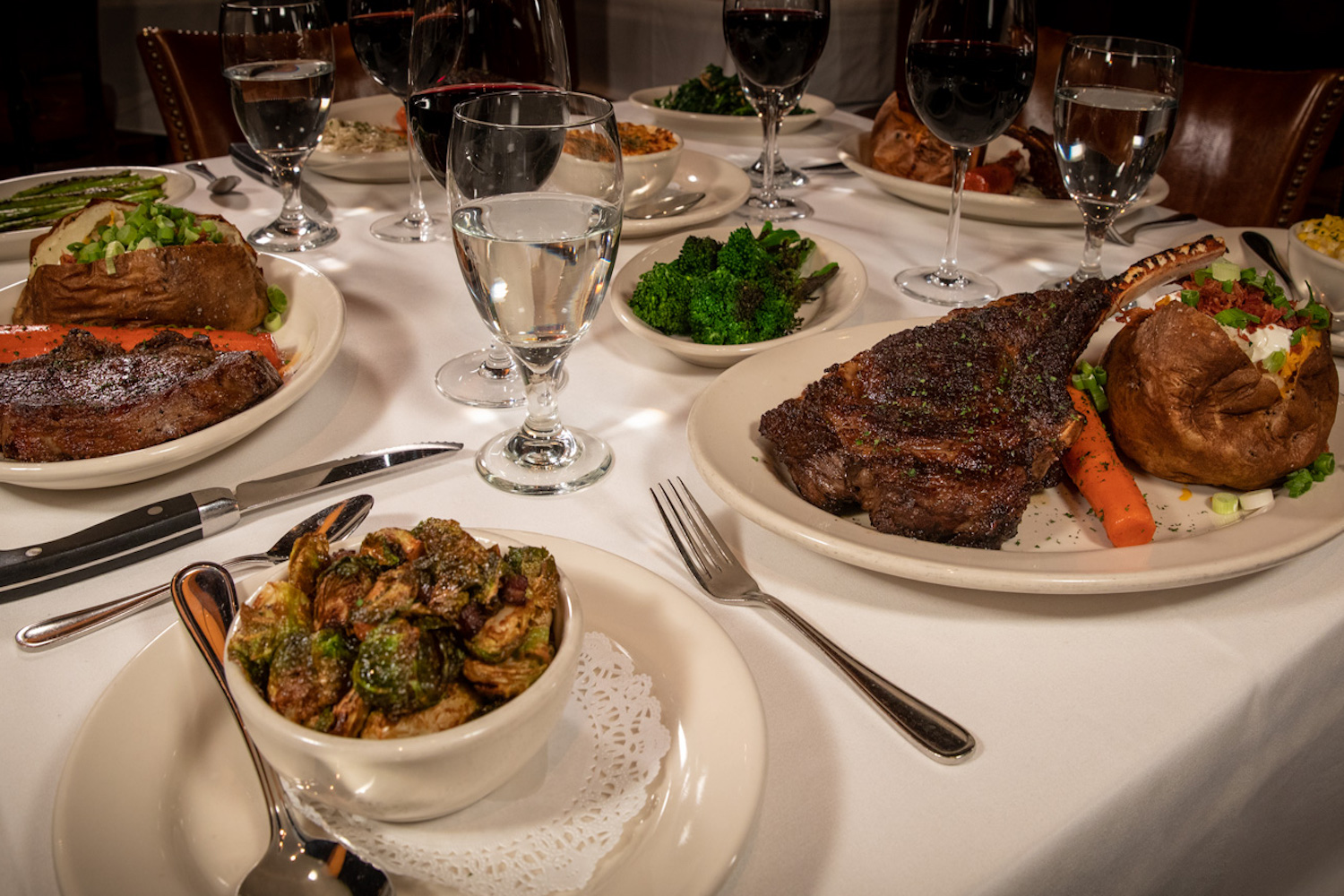 Plated steaks and other dishes at a table.