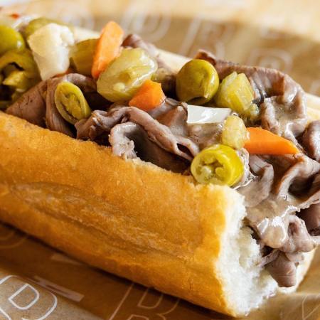 beef sandwich with banana peppers, onions and carrot on a roll