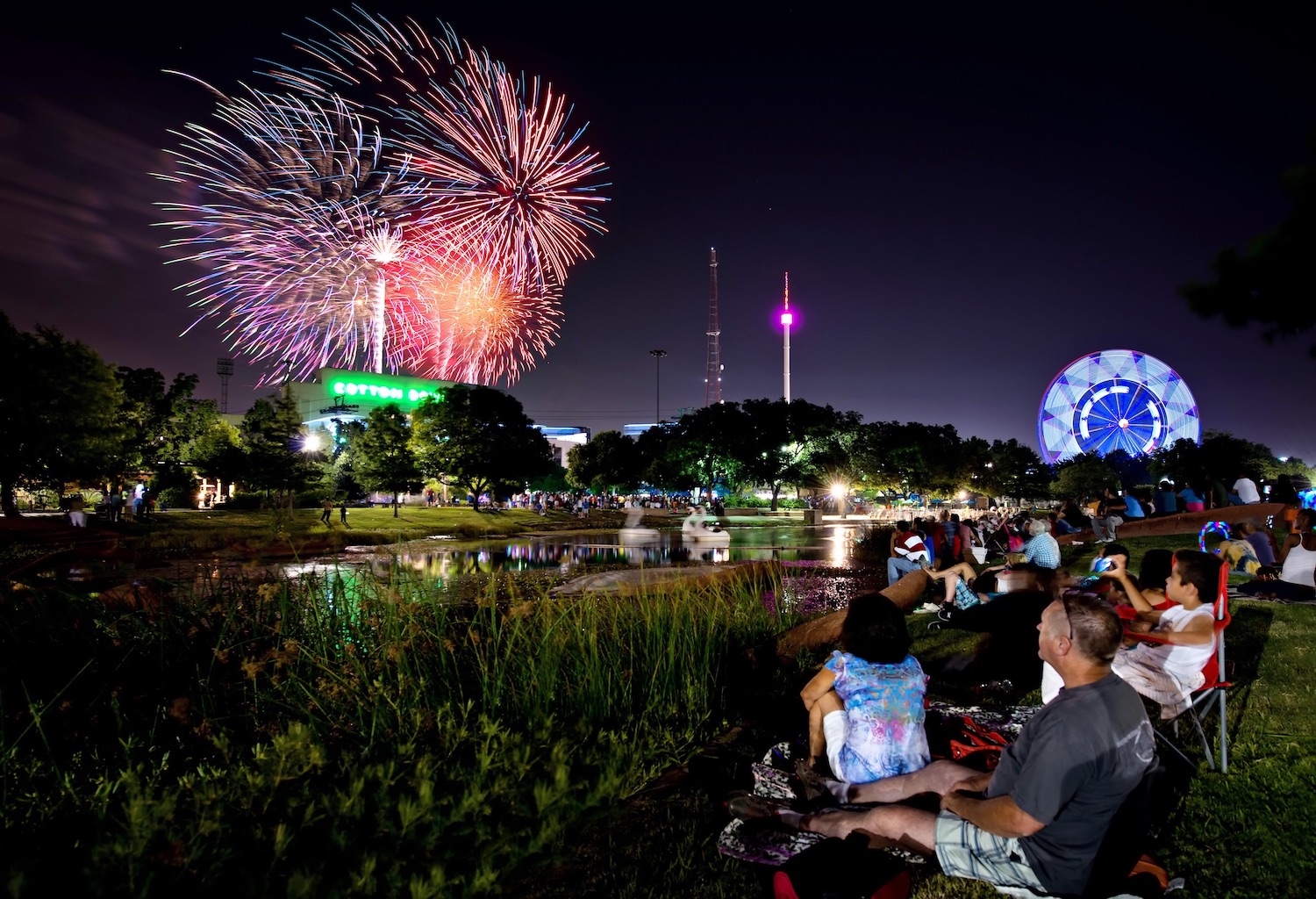 people watching fireworks happening across water