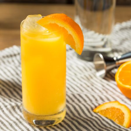 Screwdriver cocktail in a glass on a mat.