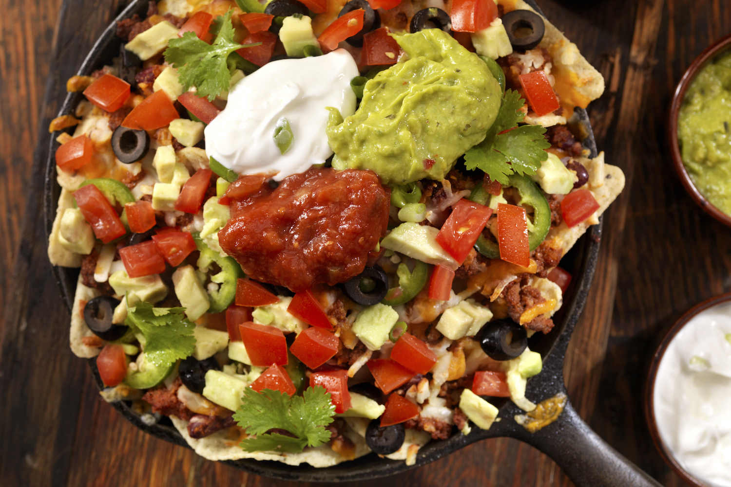 Beef Skillet Nachos in a cast iron pan on a wooden table