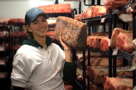 Katie Flannery posing with meat in her hand.