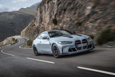 BMW car driving fast on side of mountain