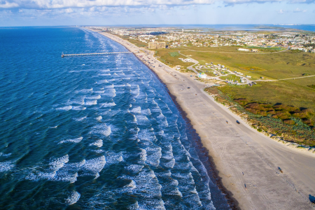 waves in ocean crashing on a beach from a birds-eye view